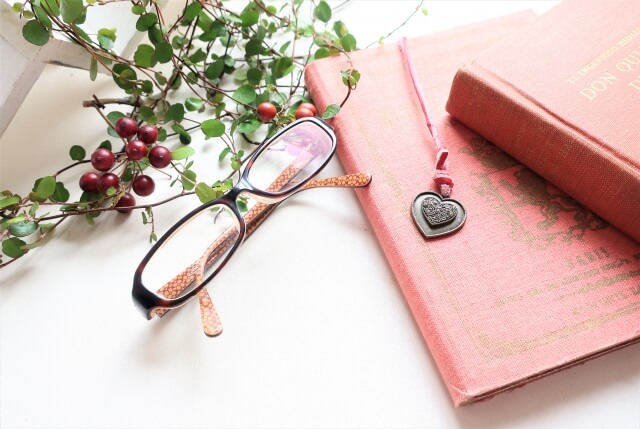語学に必要な物,机の上のピンクのノート, メガネ